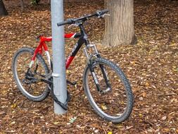 a bicycle is standing near a metal pipe