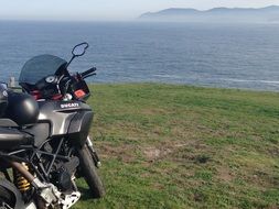 black motorcycle on the green sea coast