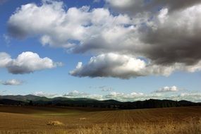 greater white clouds above the field