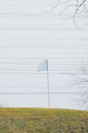 White flag golf course wires in sky view