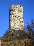 aged stone tower on hill at blue sky