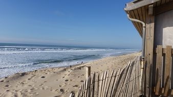 hut with wooden fence on beach, france