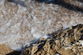 foam on the sand by the sea