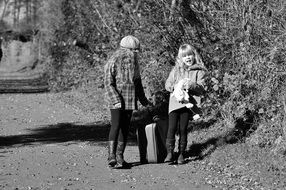 black and white photo two girls with luggage