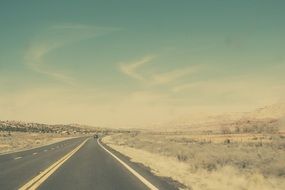 highway through desert under blue sky