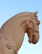 Stone statue of the horse head at blue sky background