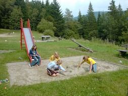 children playing in sand pit on playground