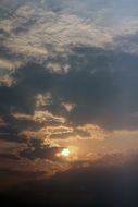summer sun behind storm clouds