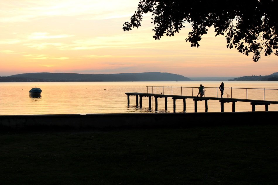 people on the pier against the orange sky in Austria