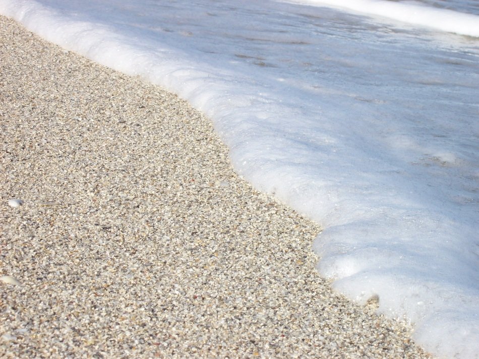 white beach sand and foam wave