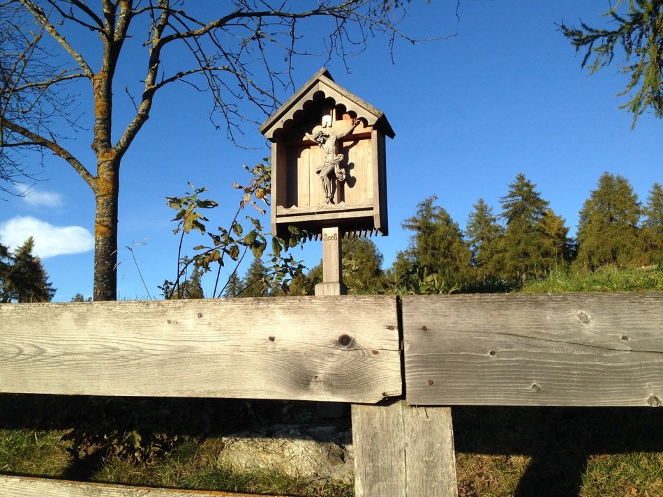crucifix on a wooden fence among the plants