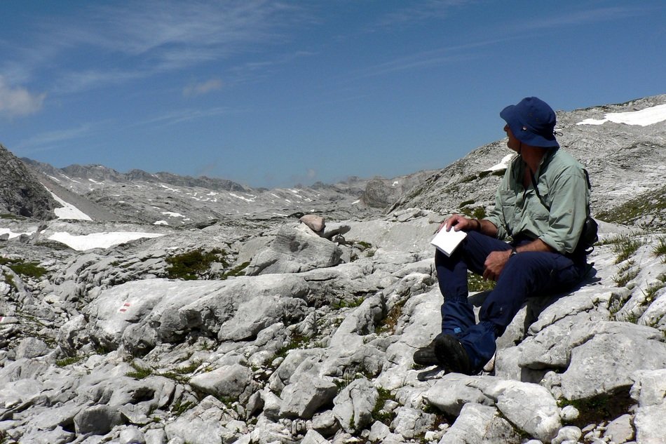 man sits on stone hills in austria