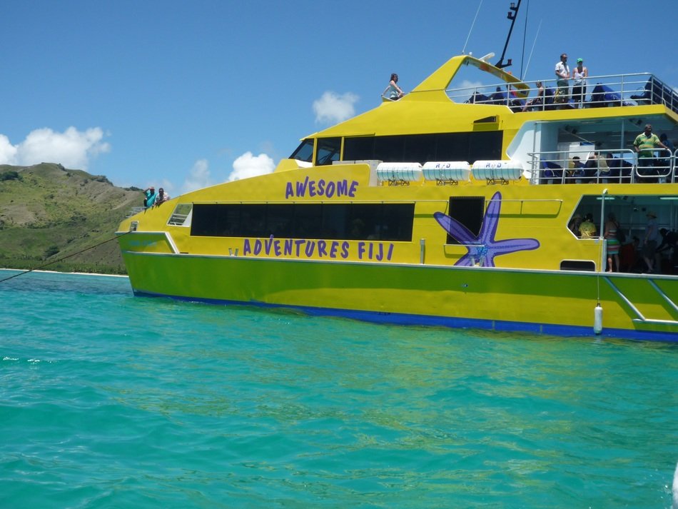 tourists on yellow yacht near the coast, fiji