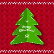 Green Christmas tree on red knitted background