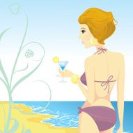 Beauty wearing bikini and holding cocktail at the beach
