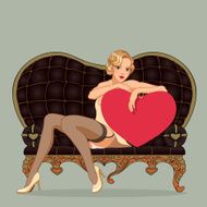 Vintage pin-up girl sitting on the black leather sofa