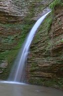 a stream of waterfall on a rock