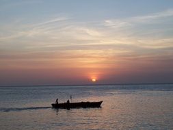 boat with fishermen in the ocean at dusk
