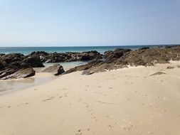 white sand and rocks at the seaside