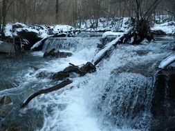 river with a waterfall in winter