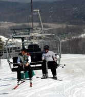 skiers on a lift in the Alps