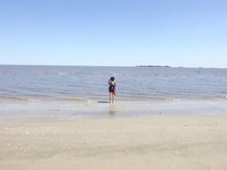 Girl near water on the horizon on a sunny day