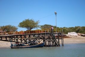 Boat on the water near a wooden bridge