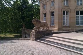 lion statue on stairs in front castle