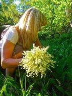 girl collects a bouquet of beautiful yellow lily of the valley flowers in Enskede, Sweden