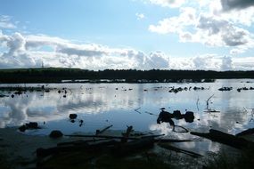 reflected in a quiet lake of the cloudy sky