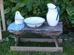 washbasin, watering can, soap dish on a wooden bench