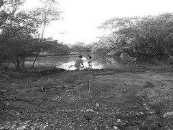 black and white photo of people near the river