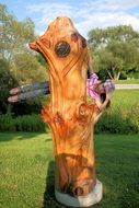 child playing on a wooden sculpture