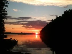 red sunset at dark forested coast
