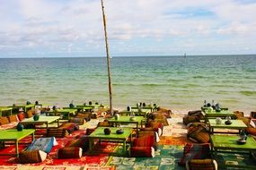 tables with chairs on the coast near the water