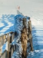 wooden fence at the foothills of the Alps in winter