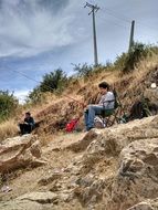 men sit by the lake