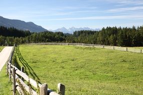 wooden fence in the meadow near the mountains