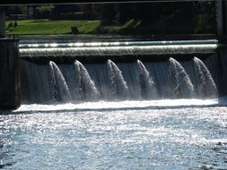 dam, river water falling down in green landscape