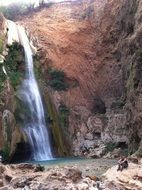 landscape of pensive man on a waterfall background