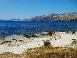 blue sea and white sand on a background of mountains
