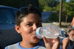 boy in sunglasses water in bottle