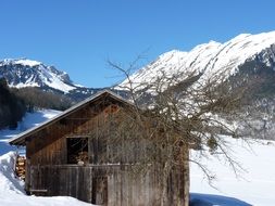 wooden hut on mountail side at snowy winter