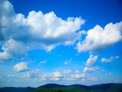 clouds low over the mountains on a sunny day