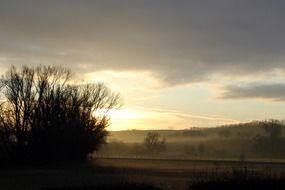 foggy sunrise in gountryside at winter