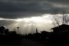 sun rays through dark thunder clouds