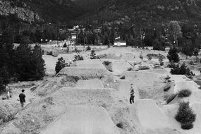 Black and white photo of dirt jumps backyard