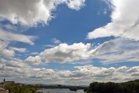 fluffy clouds above river, panorama