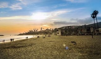 people on the beach at bright sunset