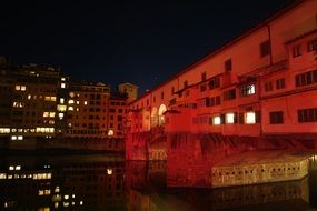 Beautiful bridge above the river in Florence with lights in Italy, at night